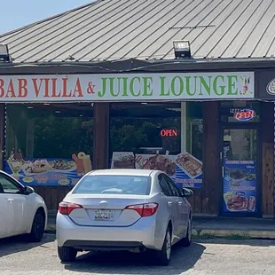 cars parked in front of a juice lounge