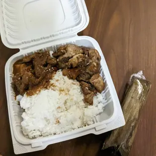 a plastic container with rice and meat