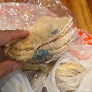 a person holding a stack of flatbreads