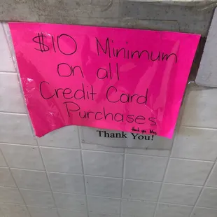a pink sign that reads $ 10 minimum on all credit card purchases thank you