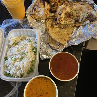 Assorted Breads, Chicken Tikka Masala, Prawn Vindaloo, Mango Lassi, and a side of basmati rice