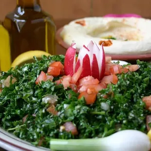 a plate of salad and a bottle of olive oil
