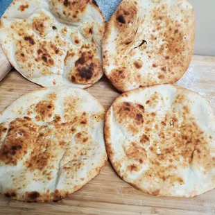four flatbreads on a cutting board