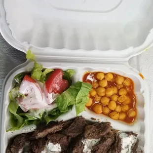 a tray of food with beans, lettuce, and meat
