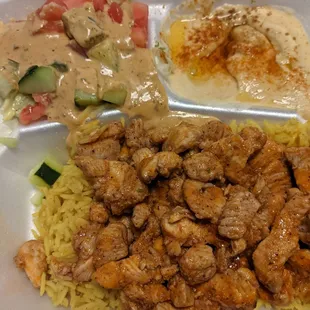 Chicken schwarma on rice with salad, oily hummus and pita bread
