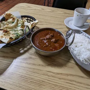 a bowl of curry and a plate of naan bread
