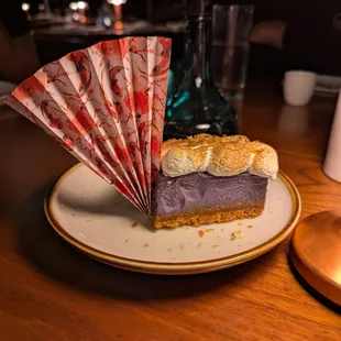 Ube Cheesecake. $14. Graham cracker crust, ube jam, topped with torched meringue, toasted coconut.