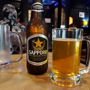 a bottle of sapporo beer and a glass of water