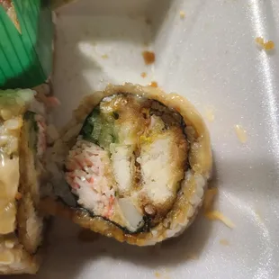 a close up of a sushi roll with chopsticks