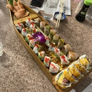 a long wooden boat filled with sushi