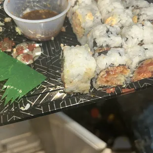 a plate of sushi and a bowl of sauce