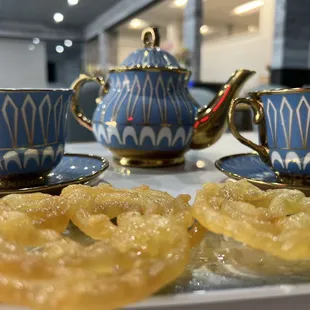 a tea pot and two teacups on a table