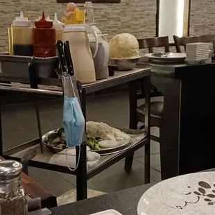 Cart with the meal ingredients  on the second shelf, sauces on top.