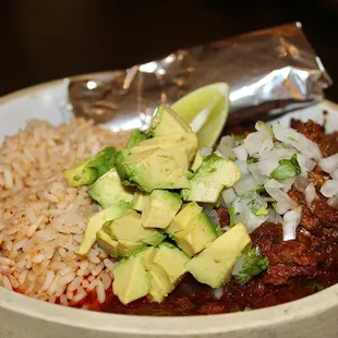 The Beef Birria is made with chili braised, arroz, onion+cilantro, avocado, &amp; tortillas.