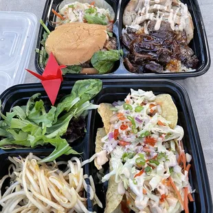 Two part bento boxes. Half and half teriyaki steak and chicken, slider, taco. Nachos, salad, marinated bean sprouts...  yummy!
