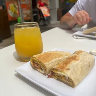 a plate of food and a glass of orange juice