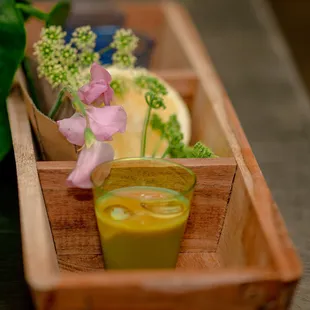 a wooden tray with a cup of tea and flowers