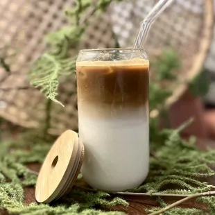 a glass of coffee with a straw