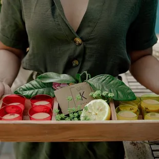 a woman holding a tray of fruits and vegetables