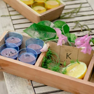 a wooden box filled with glasses and lemon slices