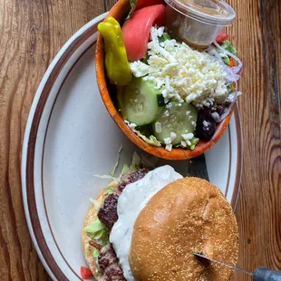 a burger and salad on a plate