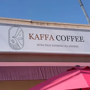 a pink umbrella outside a coffee shop