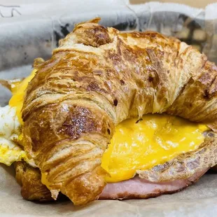 a croissant sandwich with ham and cheese