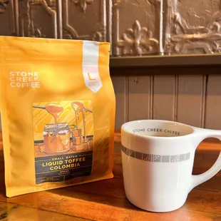 a cup of coffee next to a bag of coffee