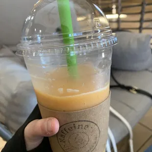 a hand holding a cup of iced coffee