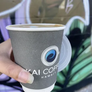 a hand holding a coffee cup