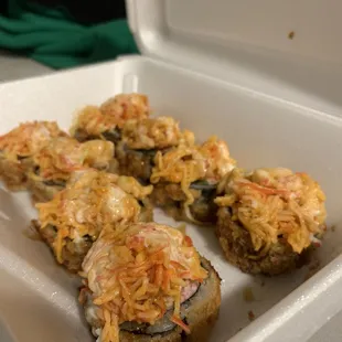 four pieces of sushi in a styrofoam container