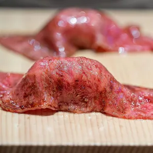 two pieces of meat on a cutting board
