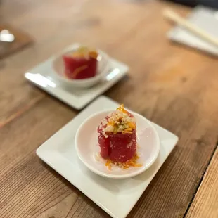 two small plates of food on a wooden table