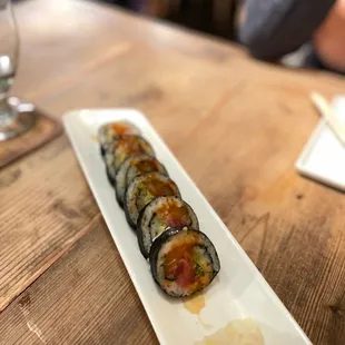 a plate of sushi on a wooden table