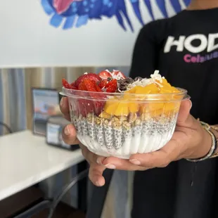 a person holding a bowl of fruit