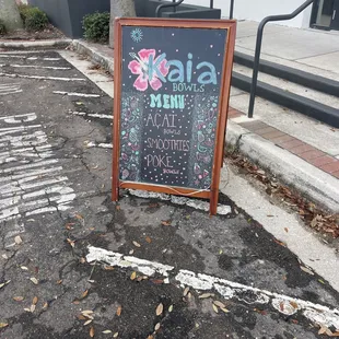 a chalkboard sign on the sidewalk