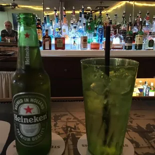 a bottle of heineken and a glass of mojitta