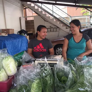 two women at a table with vegetables