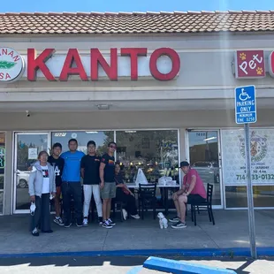 a group of people standing in front of a restaurant