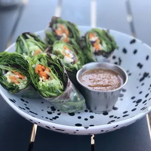 a plate of lettuce wraps with dipping sauce