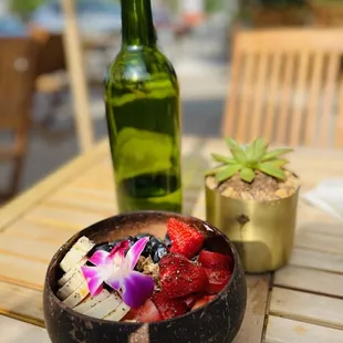 a bowl of fruit and a bottle of wine