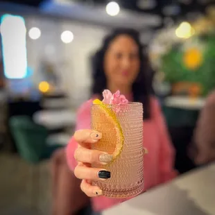 a woman holding a drink in a restaurant