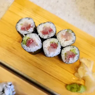 sushi rolls on a wooden cutting board