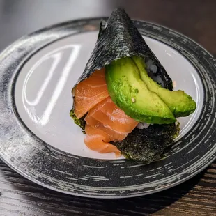 a sushi roll with salmon and avocado