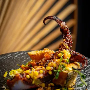 pulpo parillero an octoput dish with tempura kabocha, chalaquilla, egg yolk pellets, aji amarillo sauce