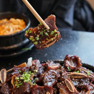 a person holding chopsticks over a plate of food