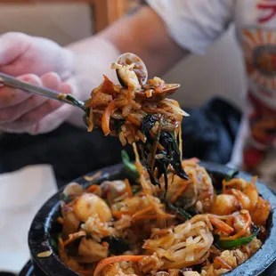 a person holding a fork full of food