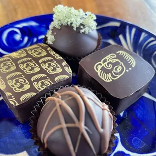 three chocolate truffles on a blue plate