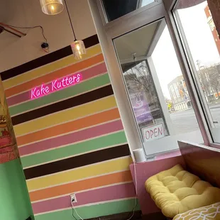 a colorful striped wall and a bench