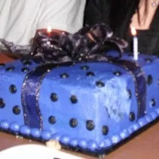 a woman sitting at a table with a birthday cake